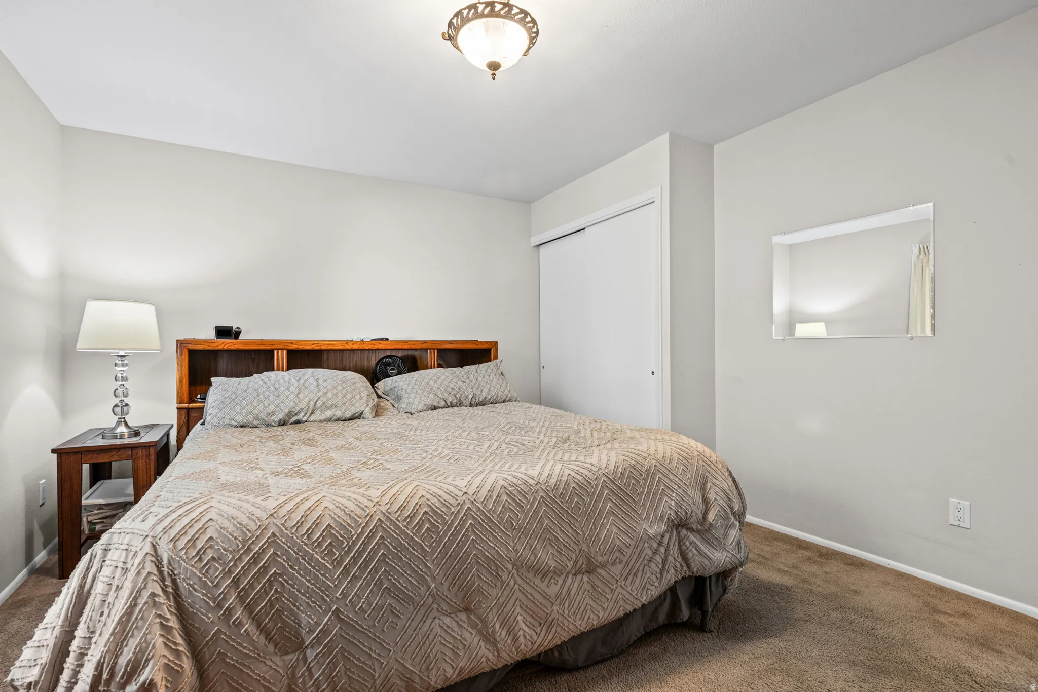Bedroom featuring light gray wall paint, brown carpeting, and a built-in closet with sliding doors