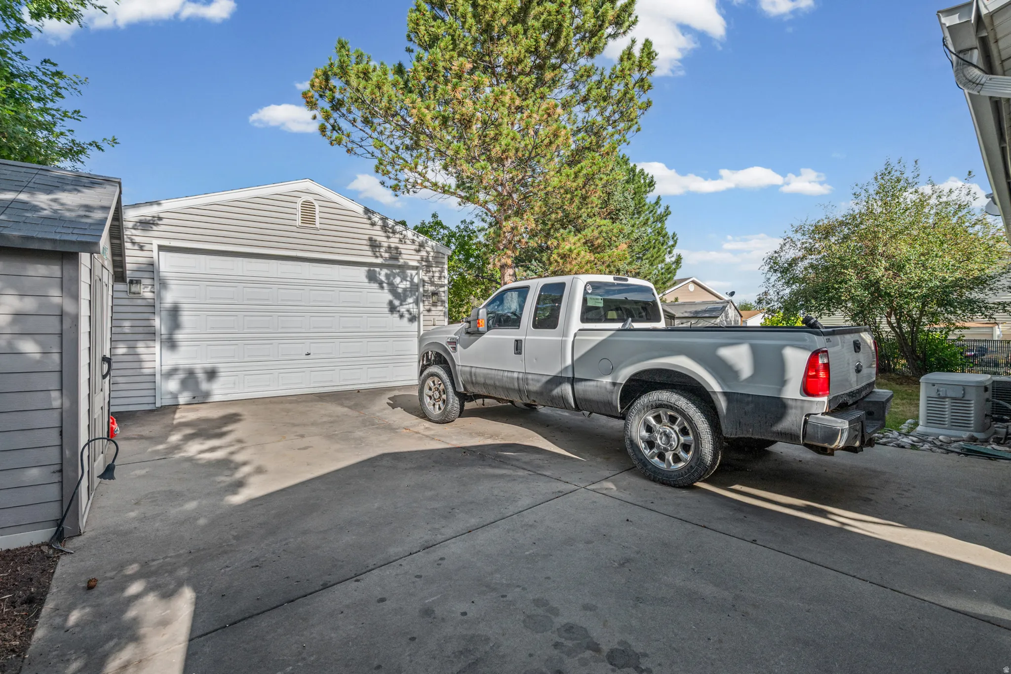 Detached two-car garage with light-colored siding and a gable vent