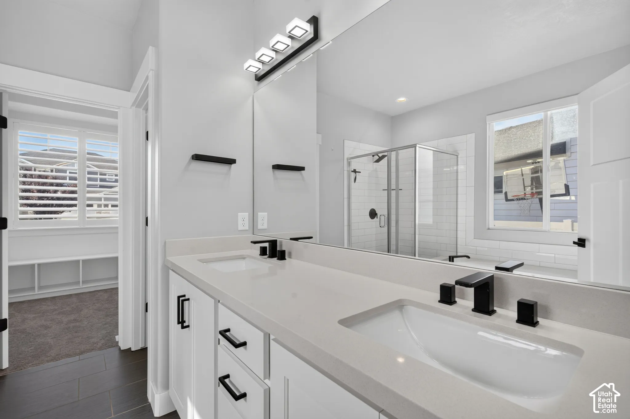 Dual vanity with integrated sinks, light-toned countertops, and matte black hardware