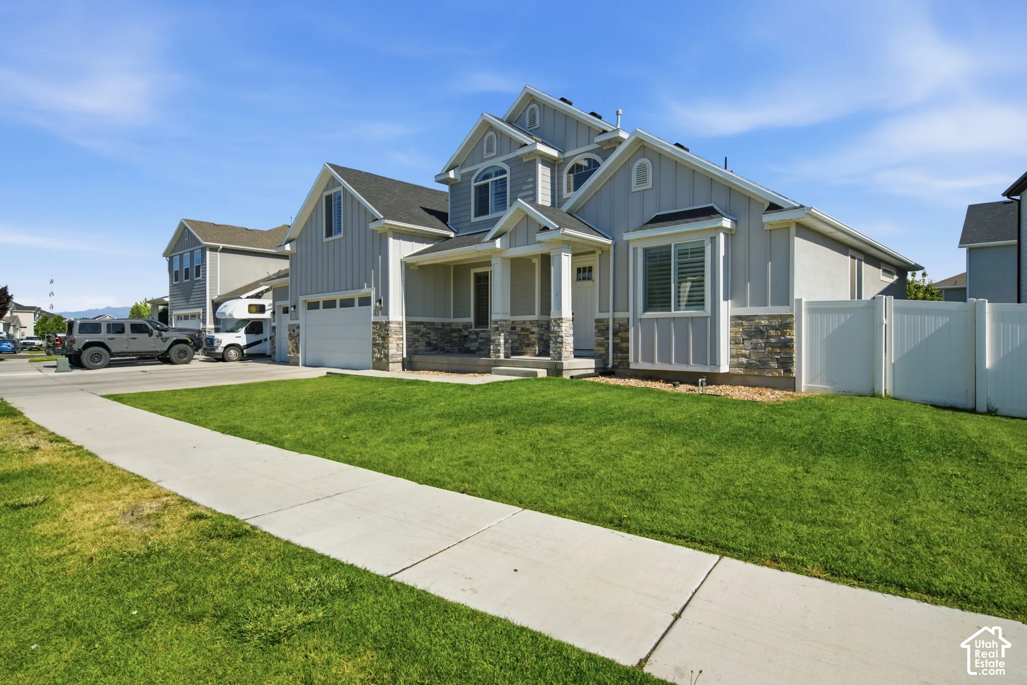 Contemporary residential exterior featuring light gray siding and stone accents