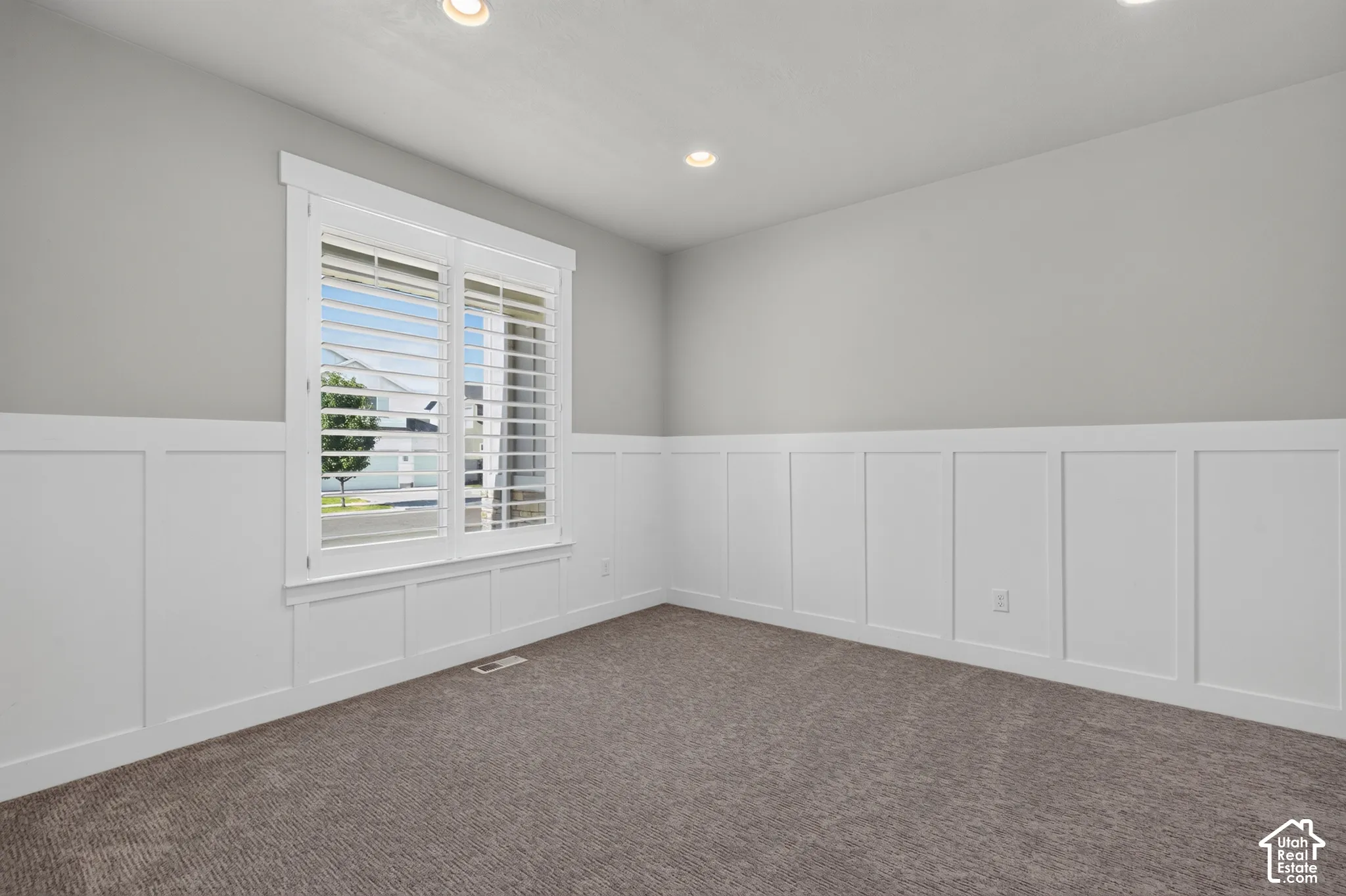 Interior space featuring wainscoting, recessed lighting, and a window with plantation shutters