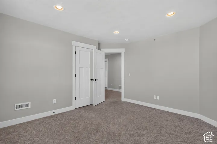 Neutral-toned carpeting extends throughout, complemented by light grey walls and white baseboards