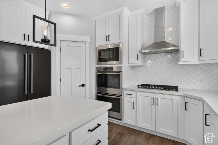 Modern kitchen featuring white cabinetry, light-toned countertops, and wood-finish flooring