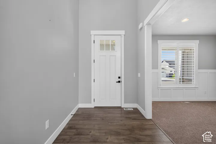 Entryway featuring wood-finish flooring, a paneled door with glass inserts, and a transom window