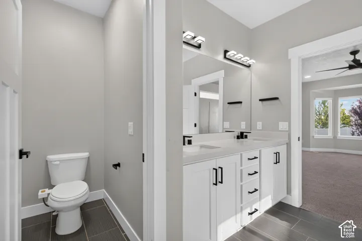Dual vanity with white cabinetry and integrated sinks, matte black fixtures, and a large mirror with contemporary lighting
