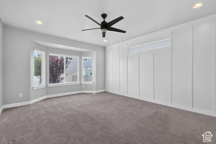 Spacious room featuring gray carpeting and a prominent bay window