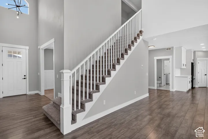 Open concept living area featuring a carpeted staircase with white balusters