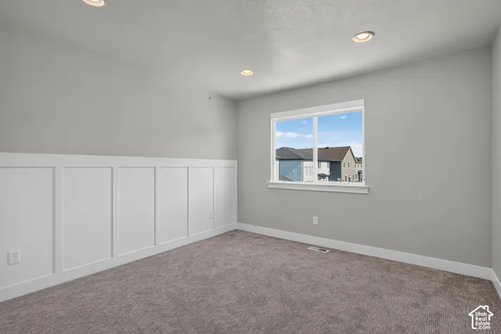Interior room featuring board and batten wainscoting, recessed lighting, and a neutral color palette