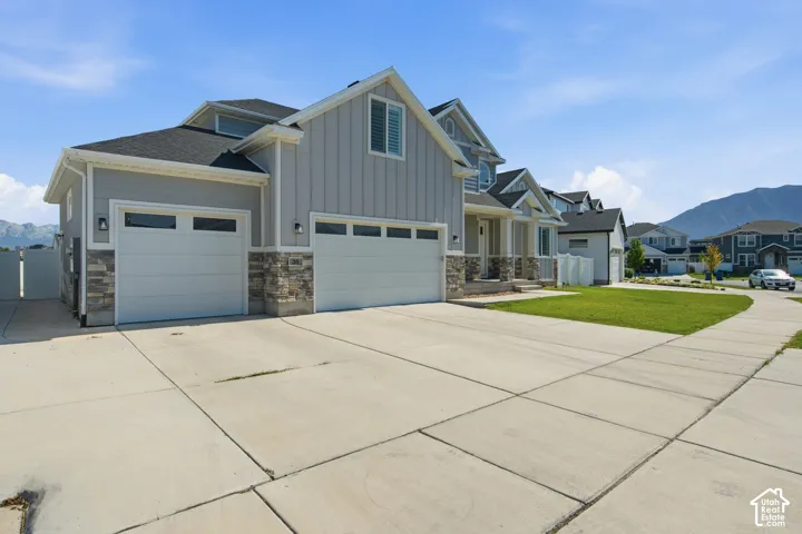 Contemporary residential exterior featuring light gray siding and stone accents