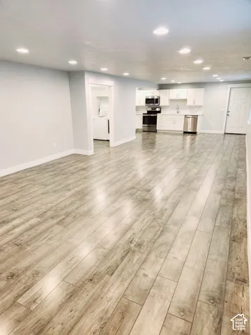 Expansive living area featuring wood-finish flooring and recessed lighting
