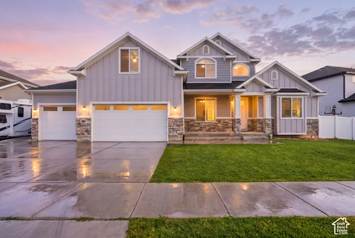 Contemporary two-story residence featuring light gray siding and stone facade accents