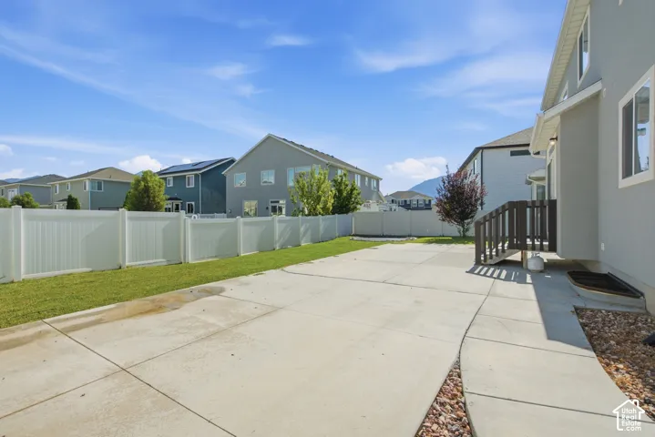 Spacious concrete patio with an expansive lawn area