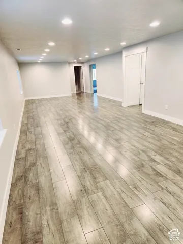 Expansive interior space featuring wood-finish flooring, recessed lighting, and light-toned wall finishes
