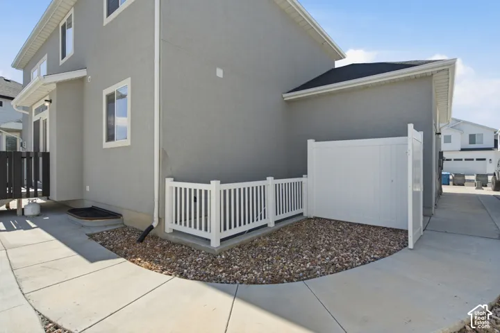 Exterior stucco finish with white trim windows and a black shingle roof