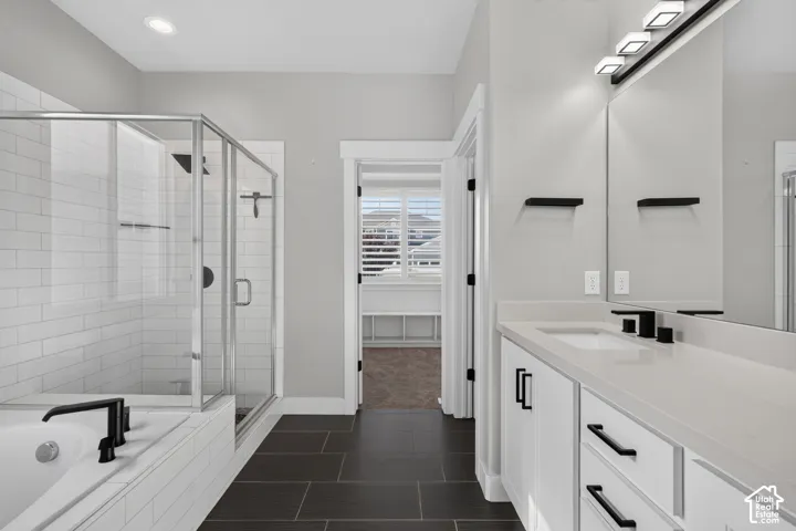 Modern bathroom featuring a double vanity with white cabinetry, light countertops, and matte black fixtures