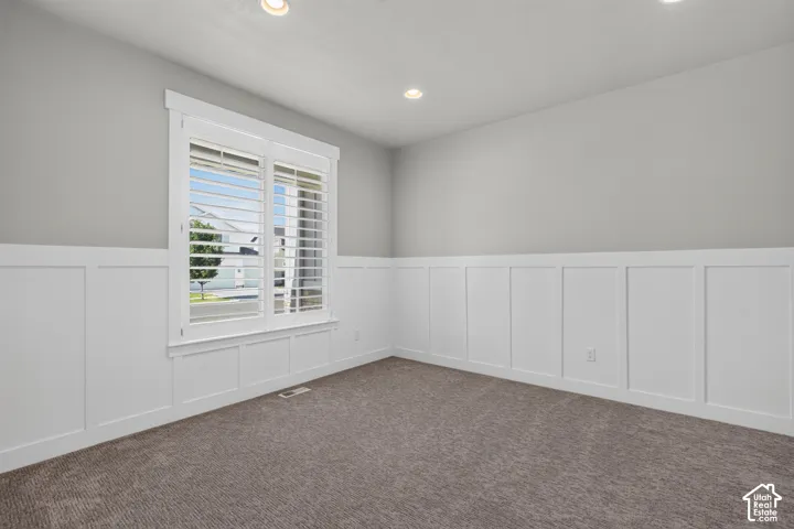 Interior space featuring wainscoting, recessed lighting, and a window with plantation shutters