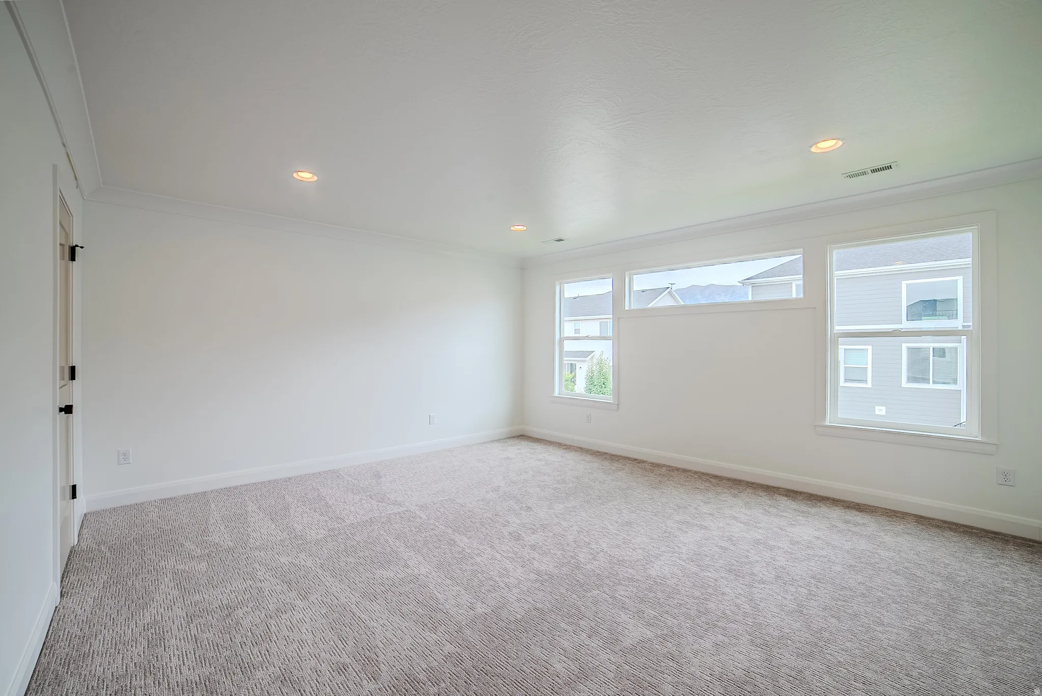 Spacious room featuring neutral carpeting and white walls