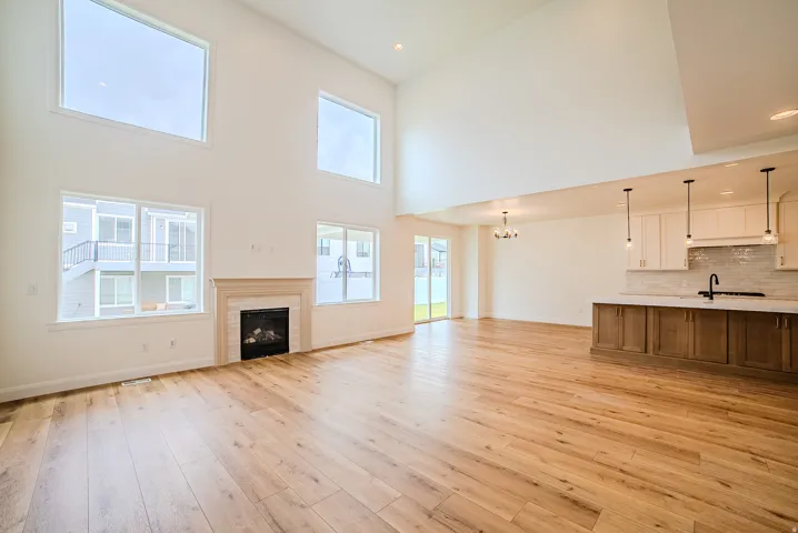 Spacious interior featuring high ceilings, wood-finish flooring, and a fireplace with a detailed mantel