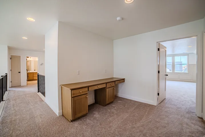 Upper-level landing featuring a built-in wood desk with drawers and cabinetry