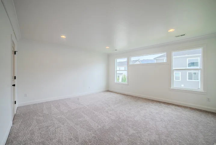 Spacious room featuring neutral carpeting and white walls
