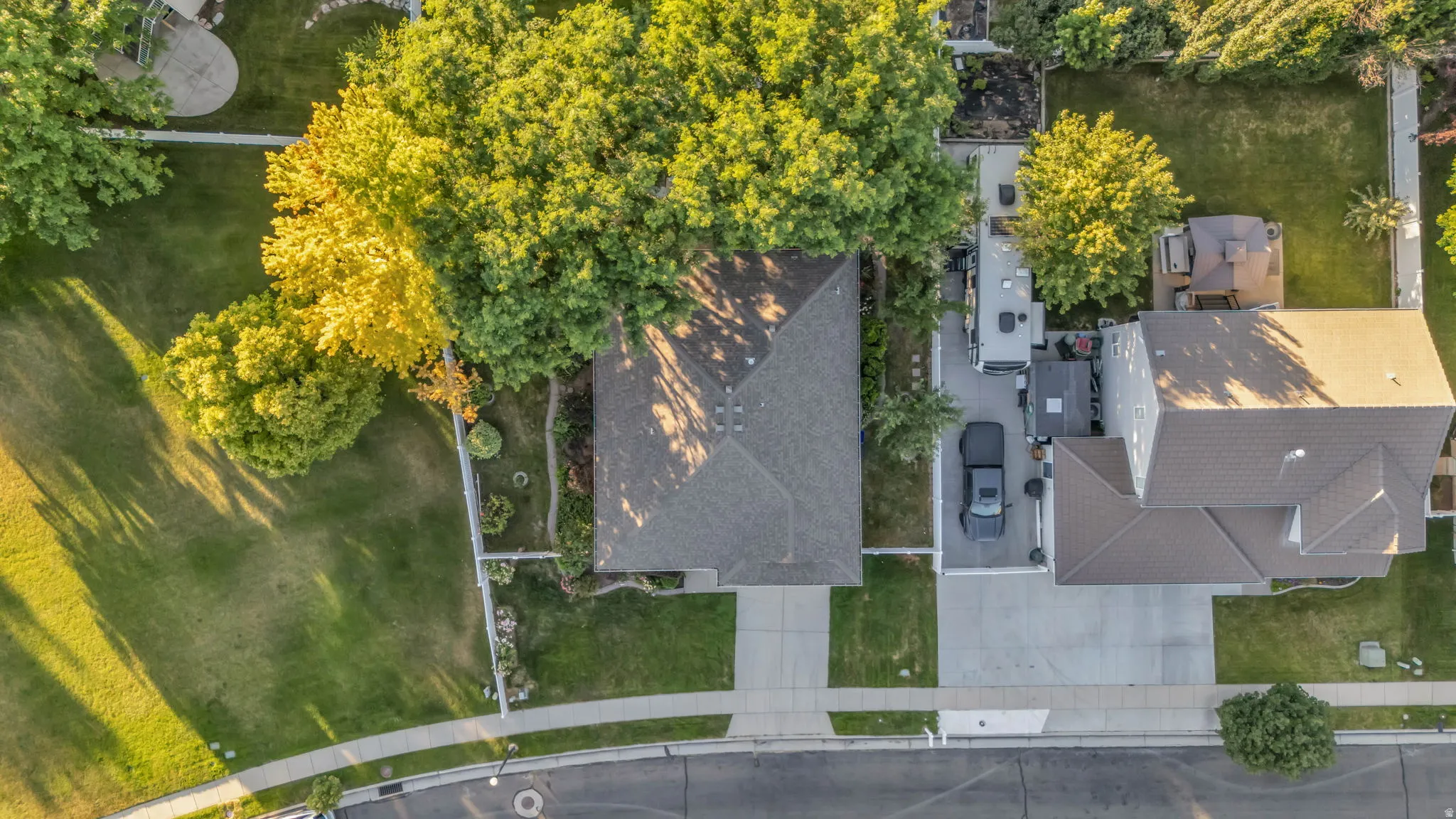 Aerial view showcasing a residential property with a gabled roof and surrounding mature trees