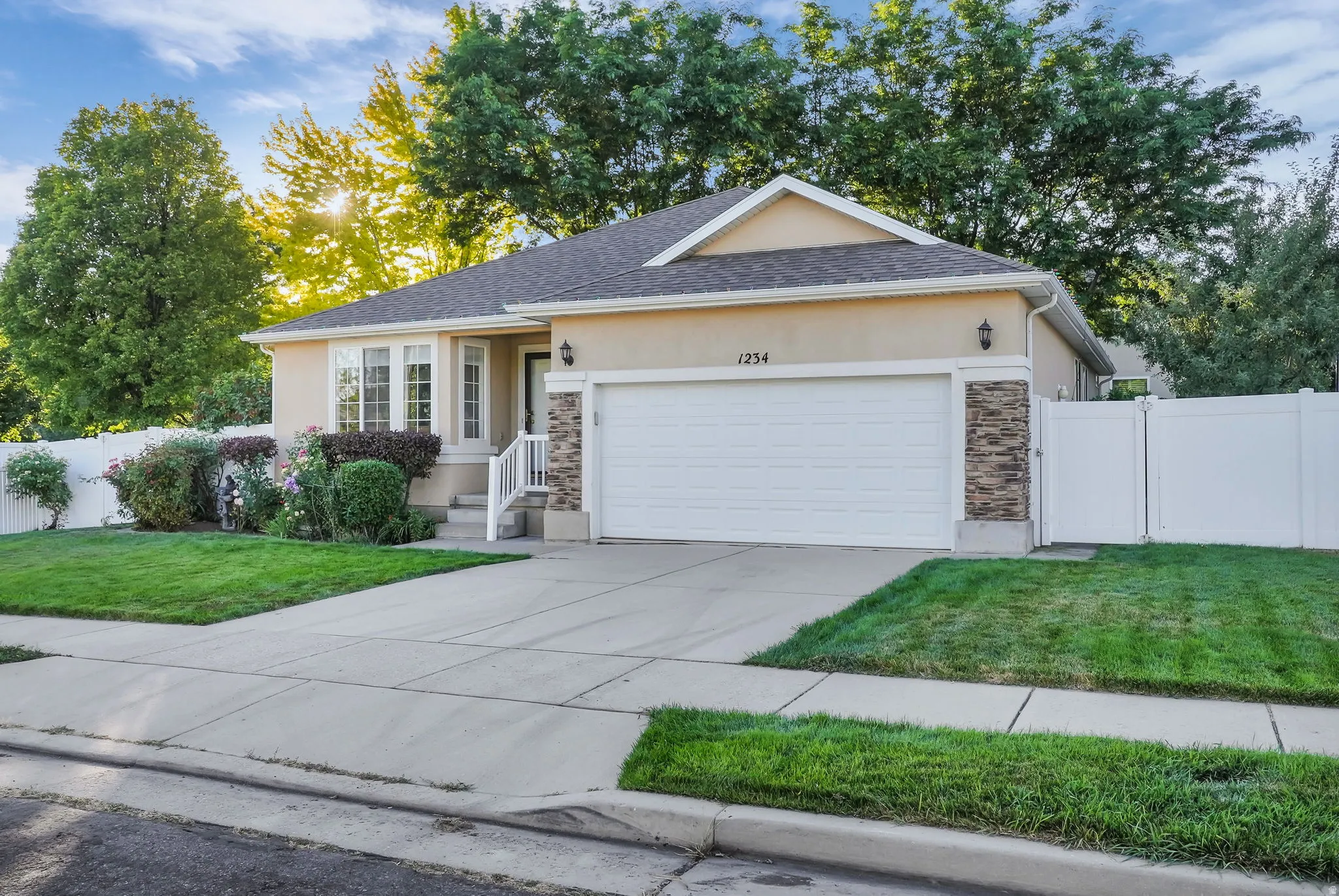 Single-story home featuring a stucco exterior, integrated two-car garage, and a bay window