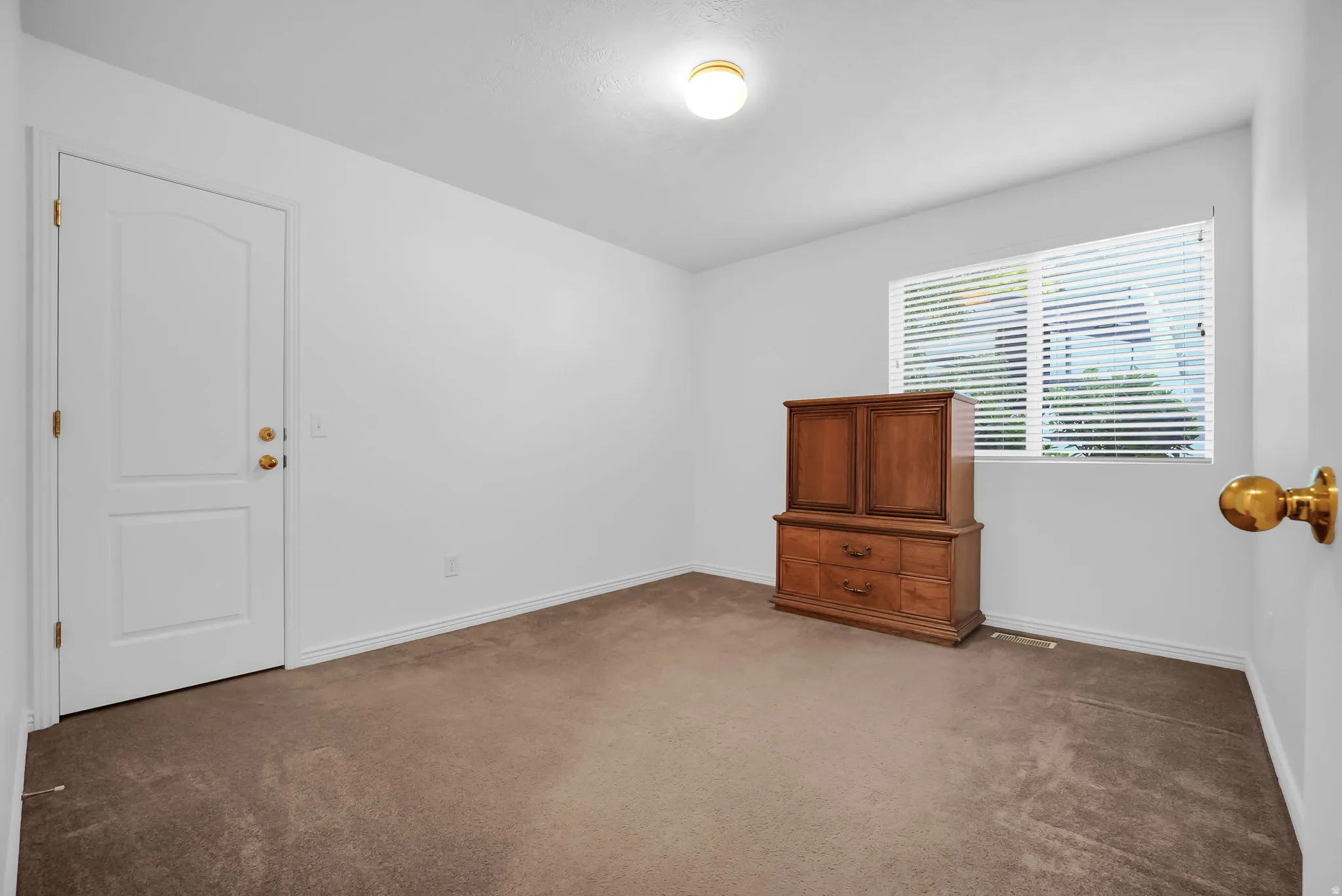 Bright room with neutral wall paint and brown carpeting