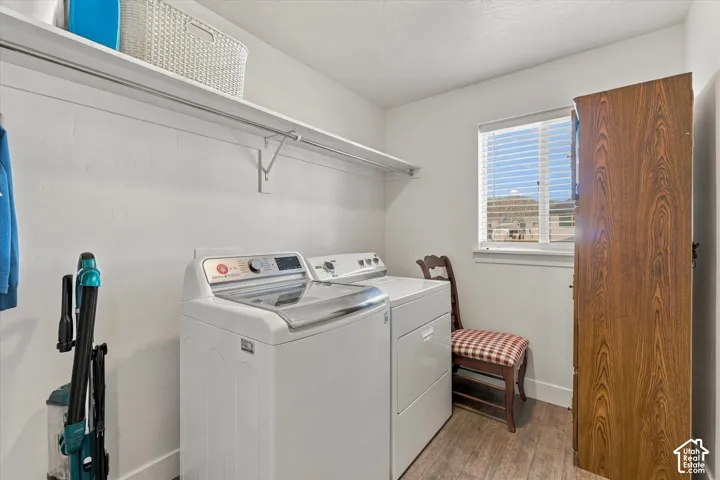 Laundry area with wood-finish flooring, a window, and a built-in shelf