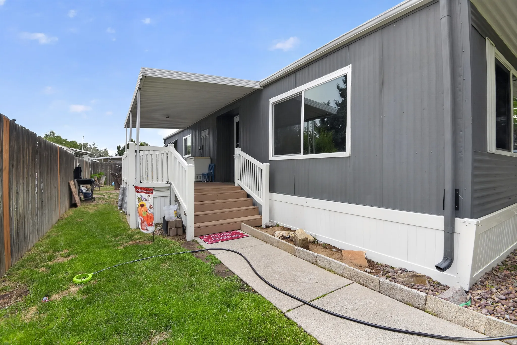 Grey exterior siding with white trim and white skirting