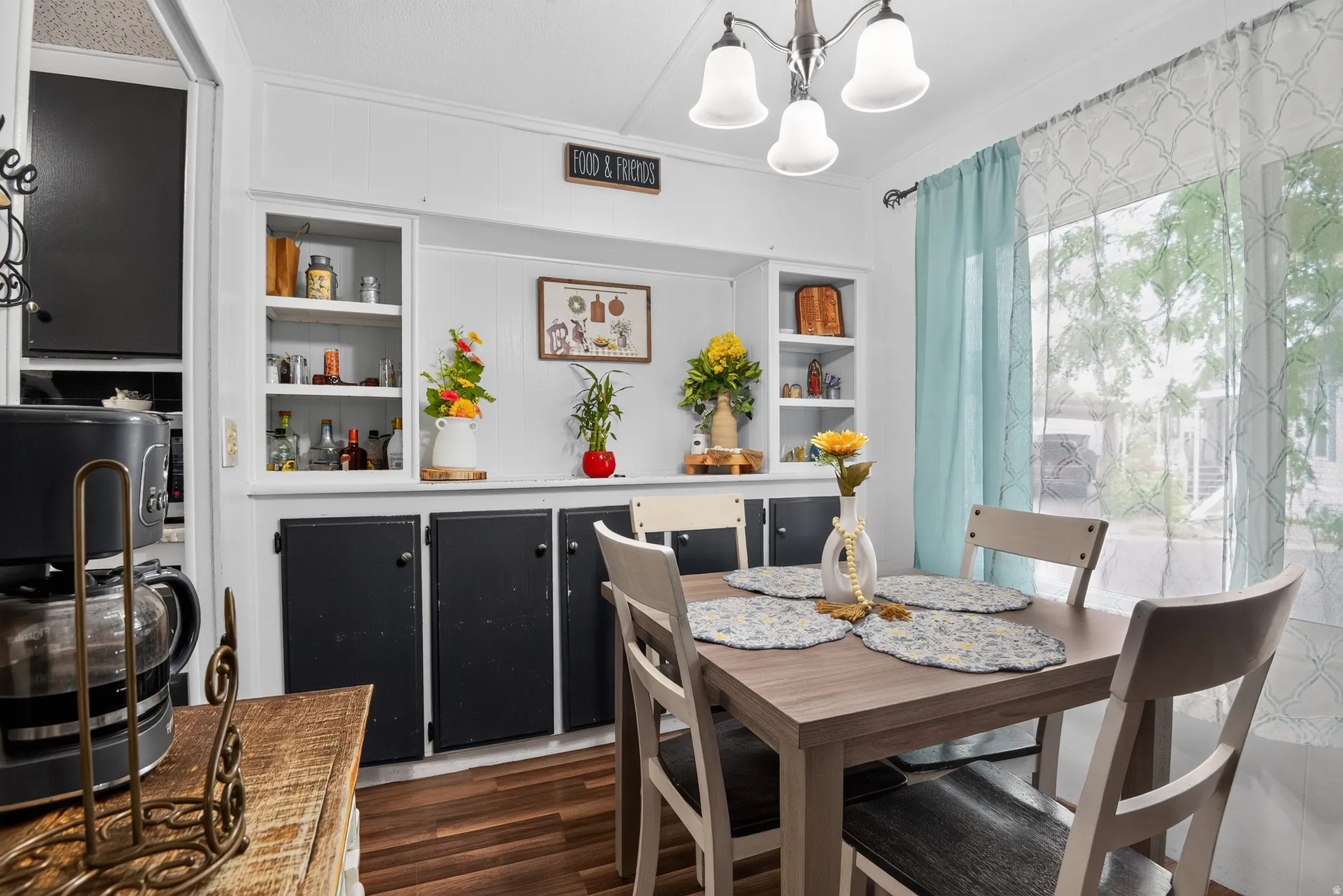 Dining area with built-in cabinetry featuring white open shelving and black lower cabinets