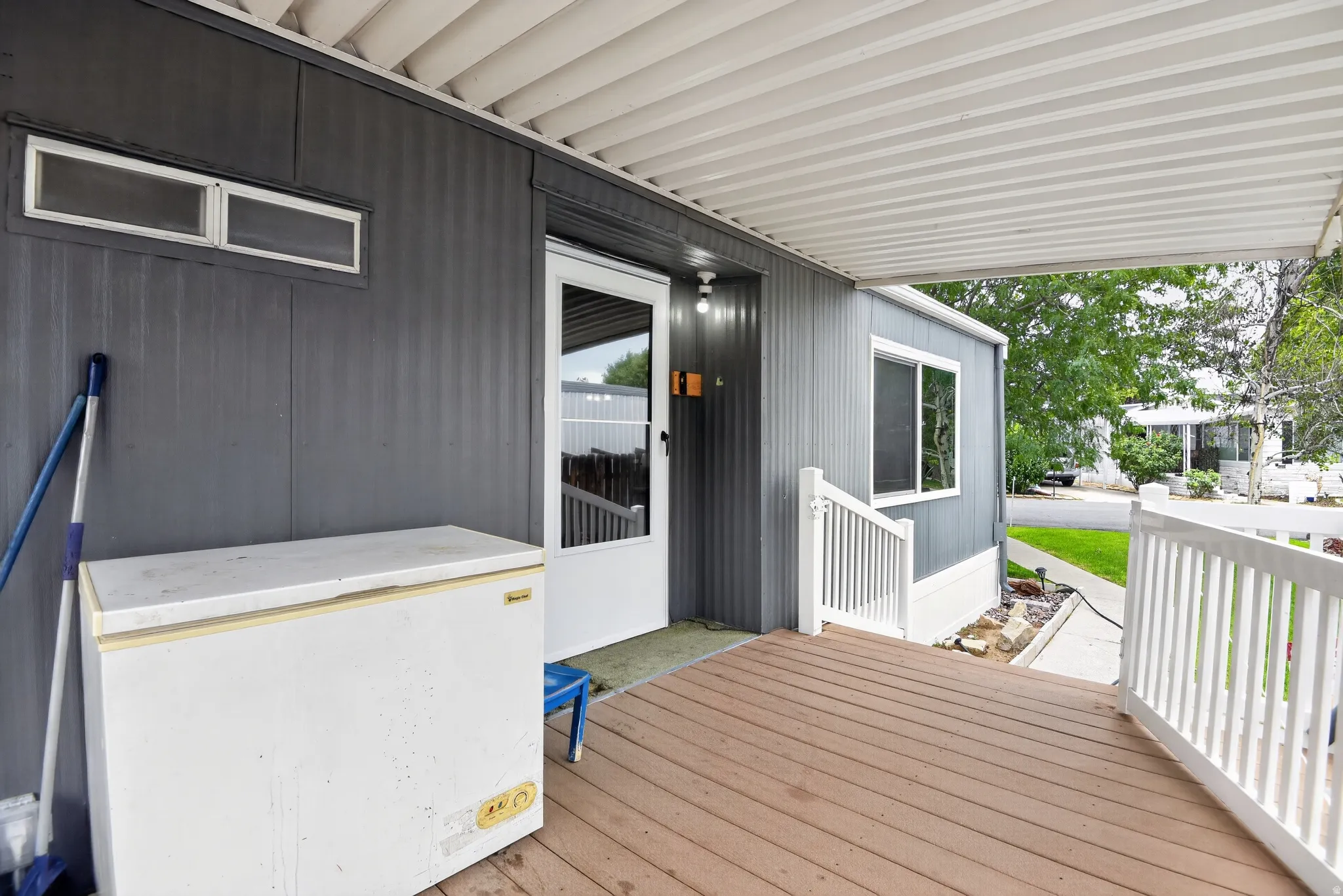 Covered porch with wood-finish decking and white railings