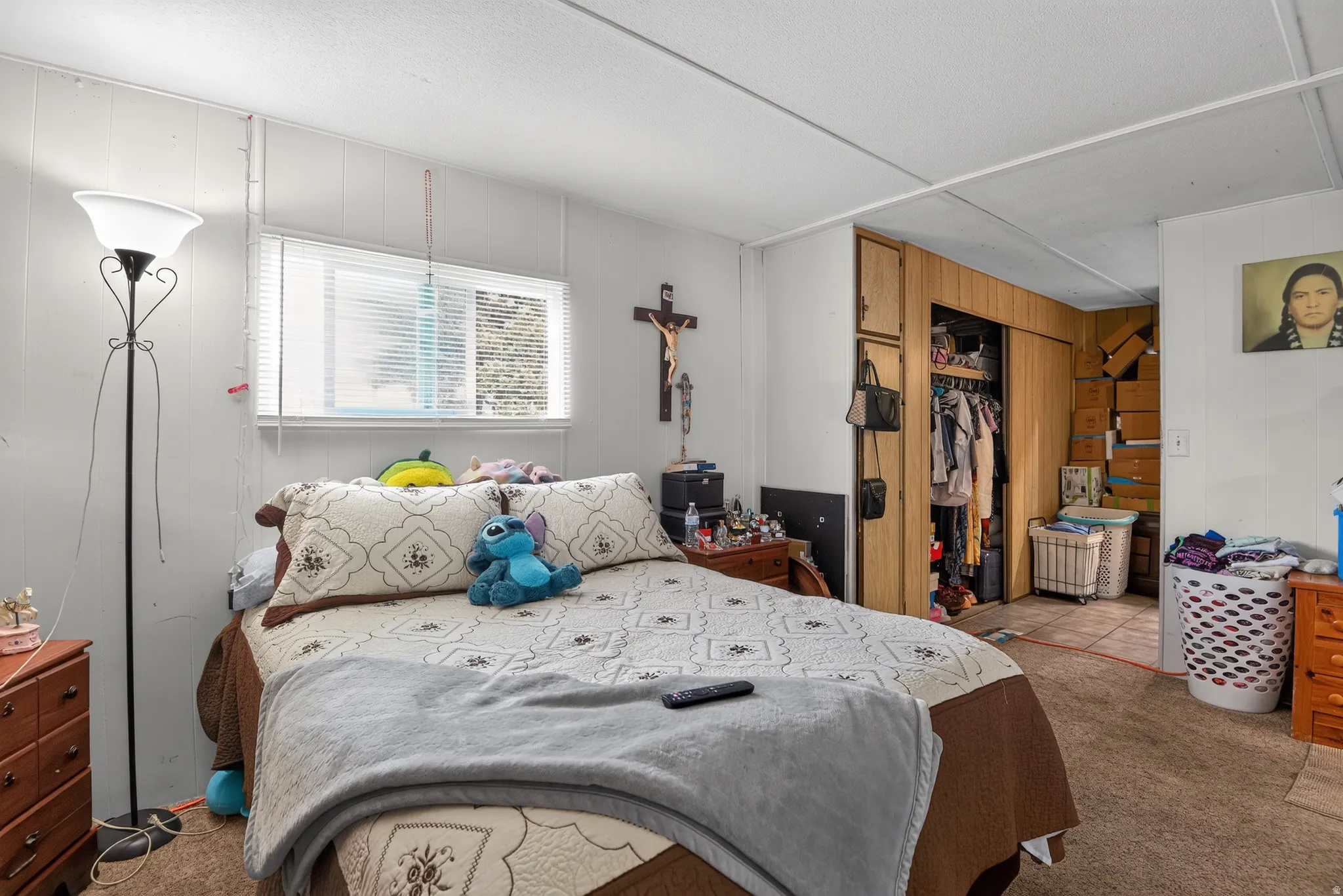 Bedroom featuring panel walls and a window with horizontal blinds
