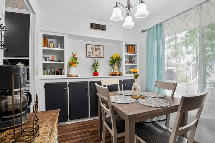 Dining area with built-in cabinetry featuring white open shelving and black lower cabinets