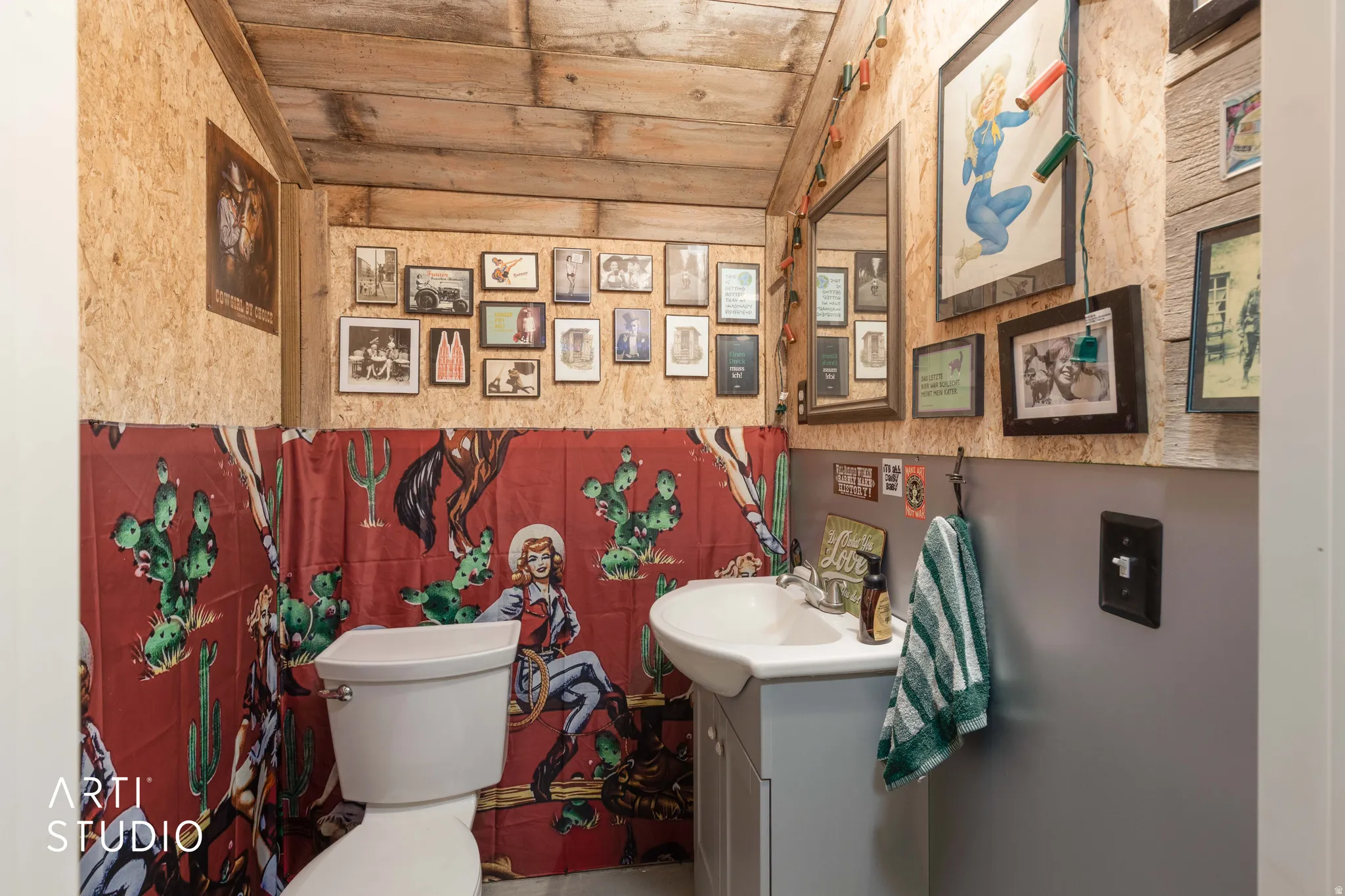 Restroom featuring wood-finish walls and ceiling, a white toilet, and a white pedestal sink with a light grey vanity