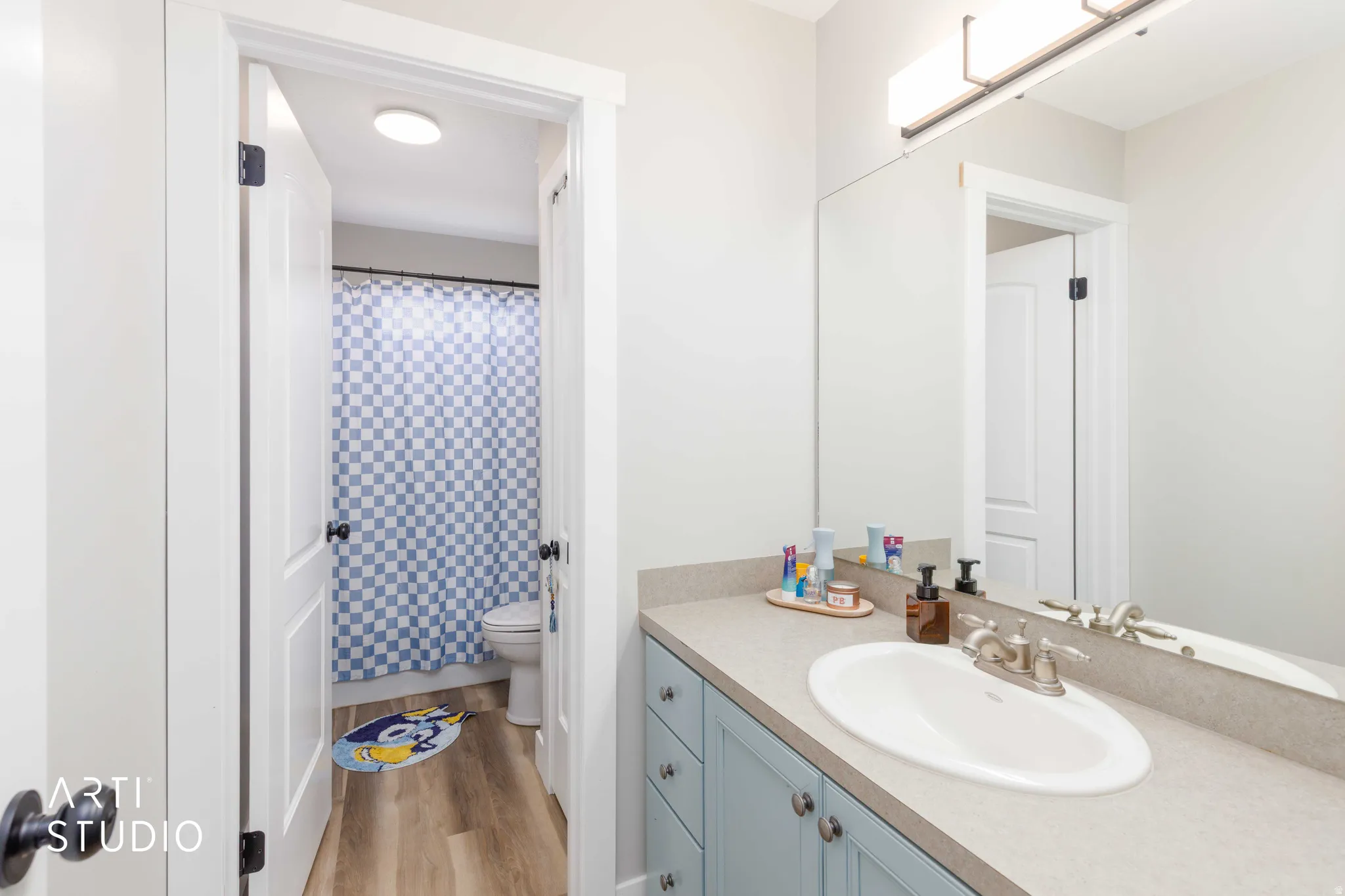 Bathroom vanity with a light countertop, integrated sink, and light blue cabinetry