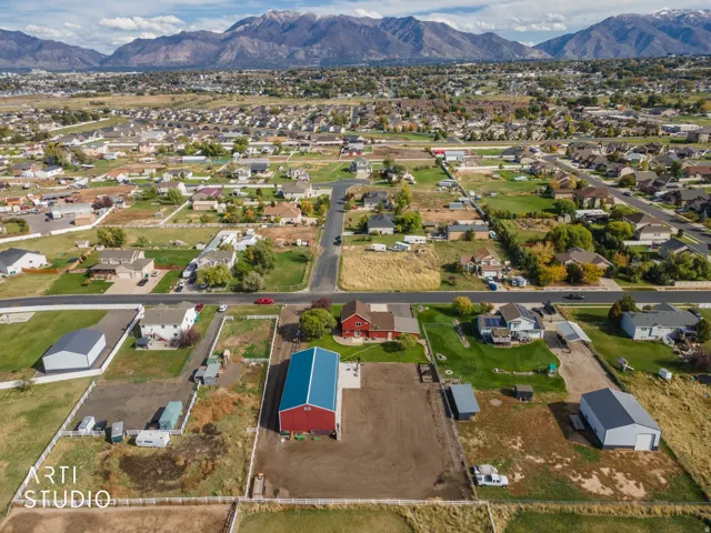 Aerial perspective showcasing a property with a red barn structure featuring a blue roof