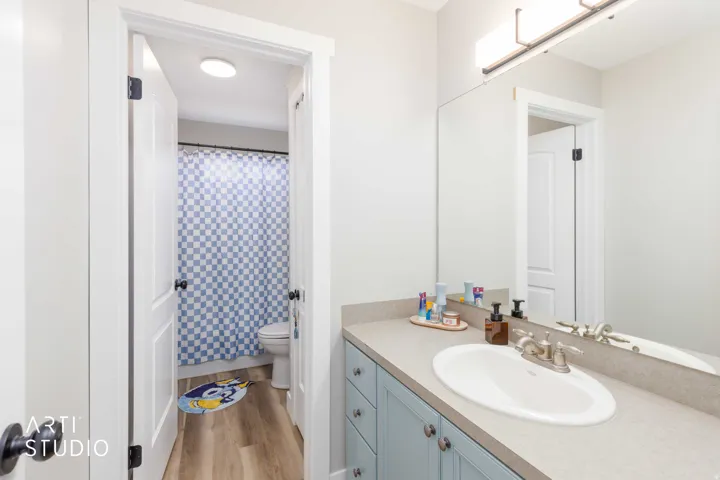 Bathroom vanity with a light countertop, integrated sink, and light blue cabinetry