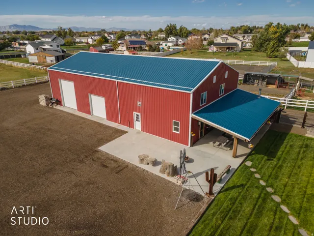 Red metal building with a blue metal roof and an attached covered patio