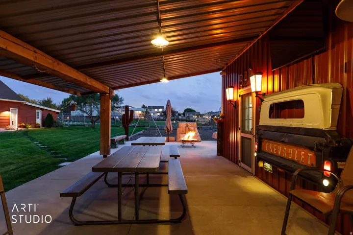 Covered patio featuring a durable metal roof, concrete flooring, and exposed wood beam supports