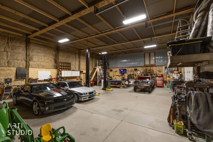 Spacious garage featuring concrete flooring and exposed wood beam ceilings