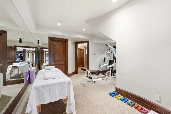 Carpeted recreation room featuring full-wall mirrors and recessed lighting