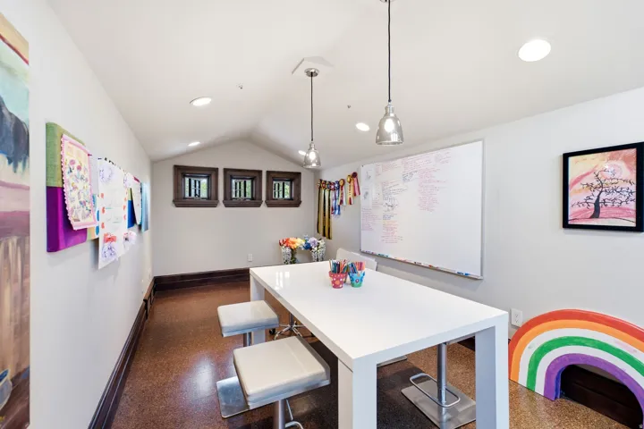 Room featuring sloped ceilings, recessed lighting, and a durable cork-finish floor