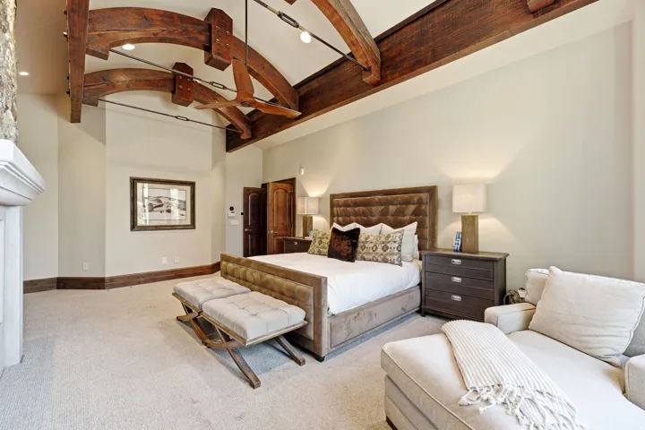 Vaulted ceiling featuring exposed wood beams and a ceiling fan