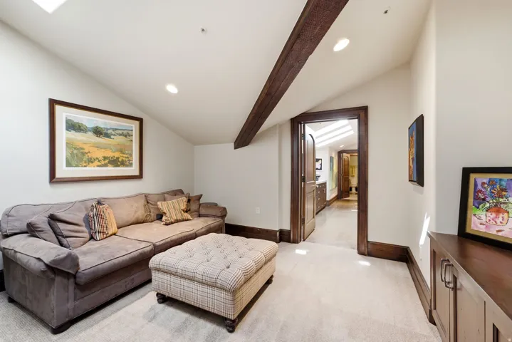Vaulted ceiling with an exposed beam, recessed lighting, and a skylight