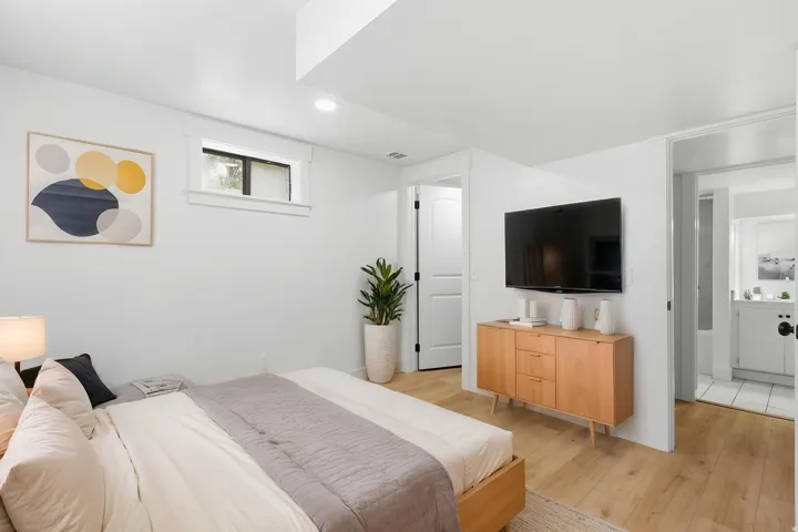 Light wood-finish flooring complements the crisp white walls and recessed lighting