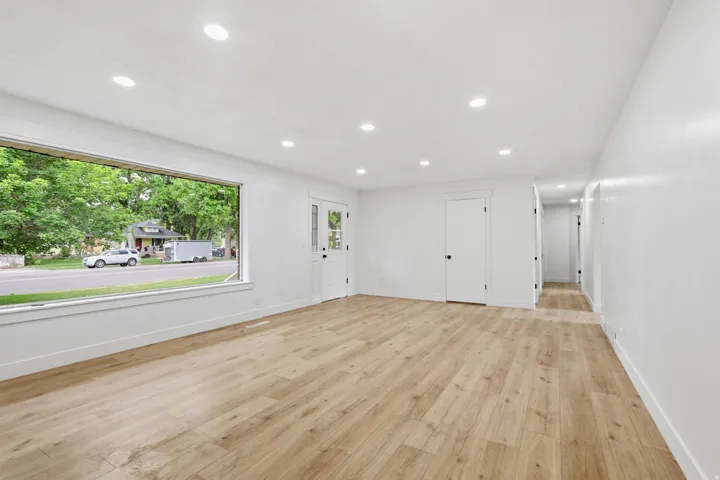 Expansive room featuring wood-finish flooring, recessed lighting, and a large picture window