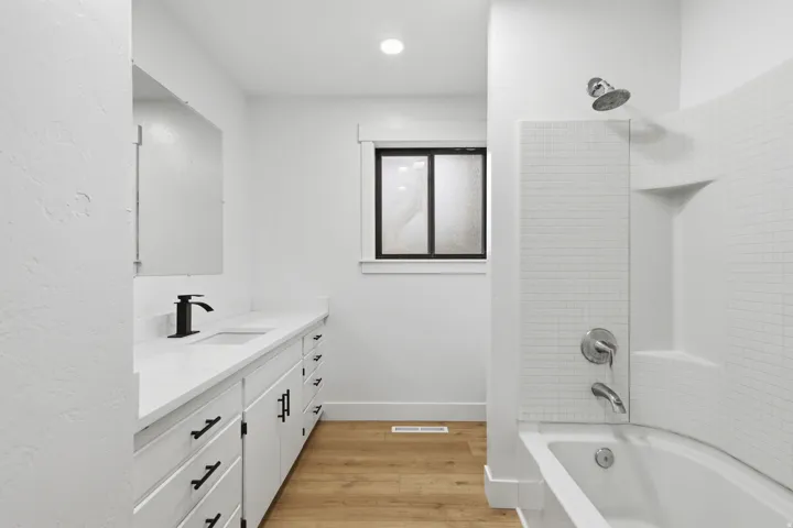 Bathroom featuring a white vanity with dual sinks, matte black fixtures, and a white countertop