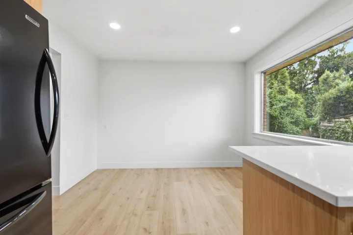 Kitchen area featuring light wood-finish flooring, white walls, and recessed lighting