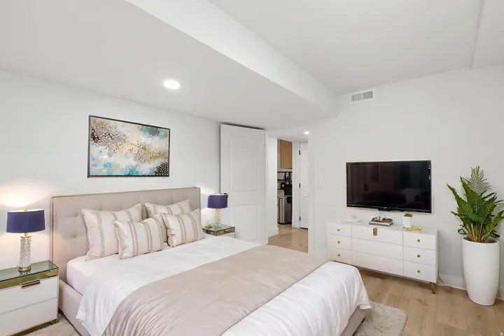 Light wood-finish flooring complements white walls with recessed lighting