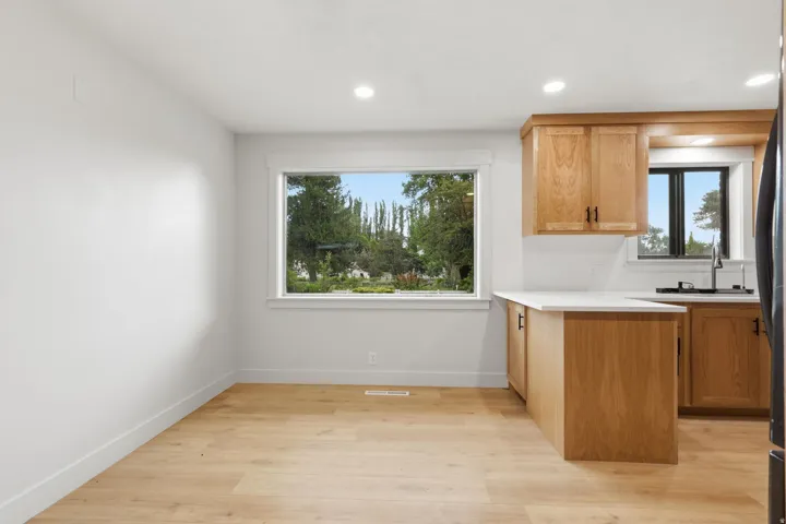 Kitchen and dining area featuring light wood-finish flooring and recessed lighting